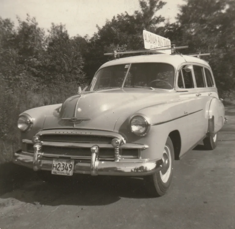 The 1950s Acadia Bus Tours touring car with its roof sign, parked on a Bar Harbor street
