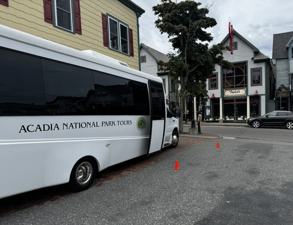 An Acadia National Park Tours bus parked on a downtown Bar Harbor street