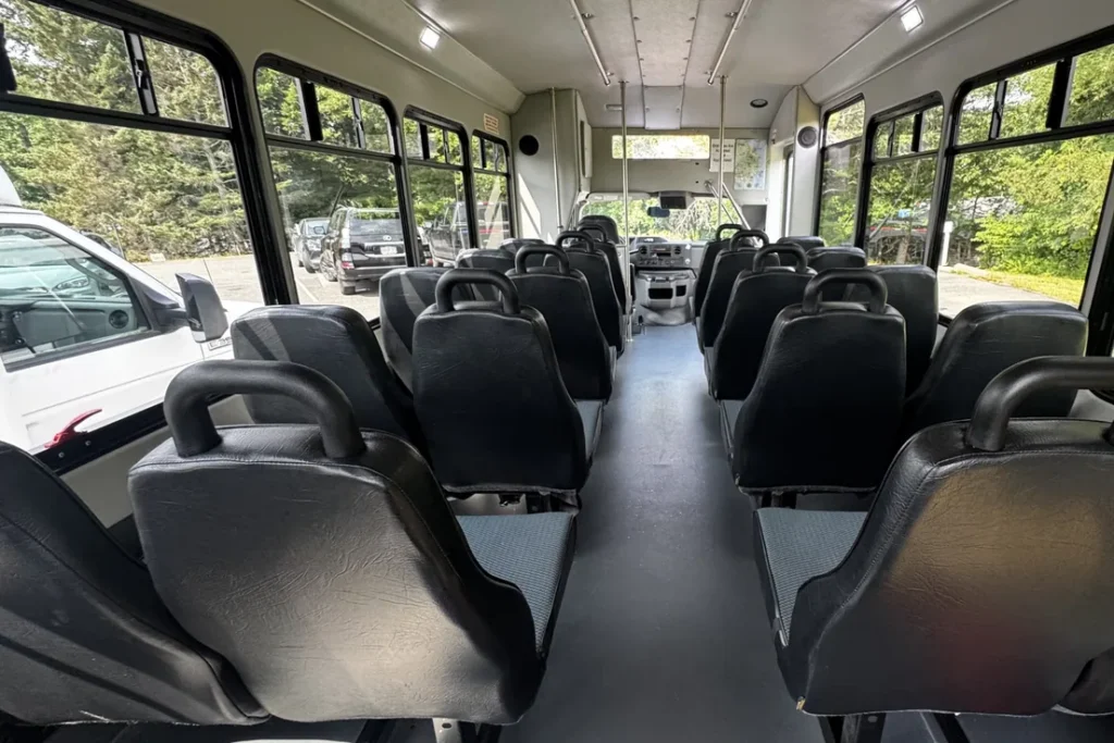 Rows of high-back seats inside the 22-passenger Acadia private tour bus
