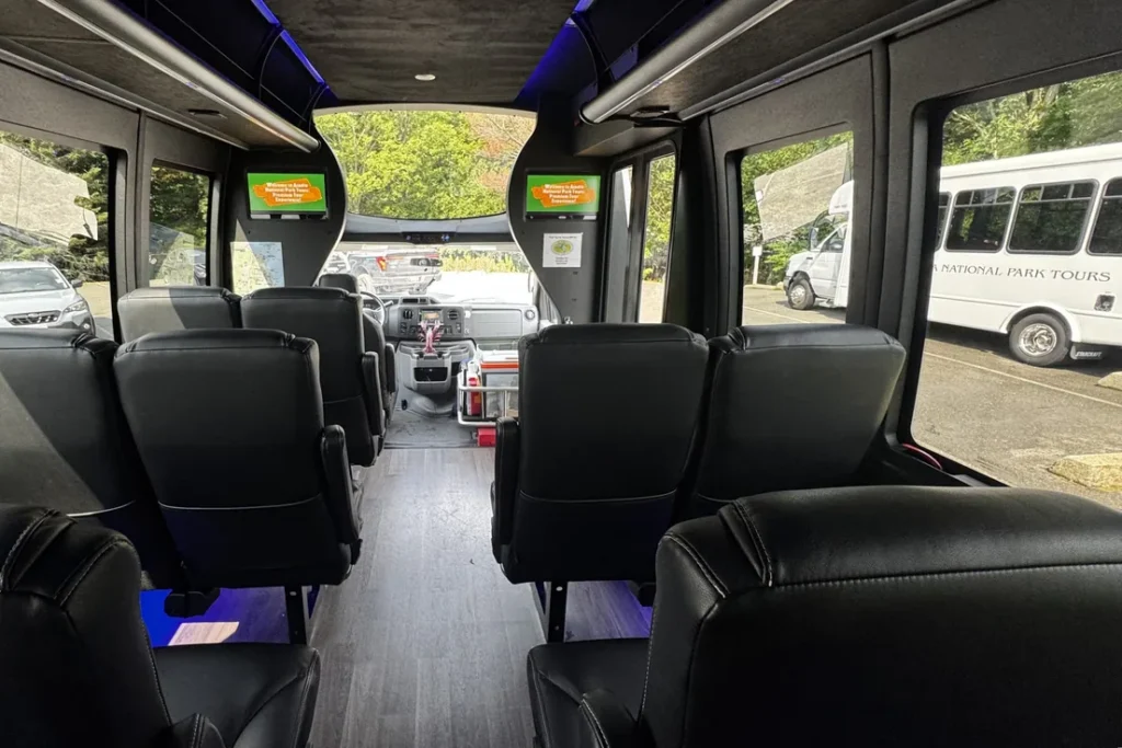 Black leather captain's seats inside the 14-passenger Acadia private tour mini-coach