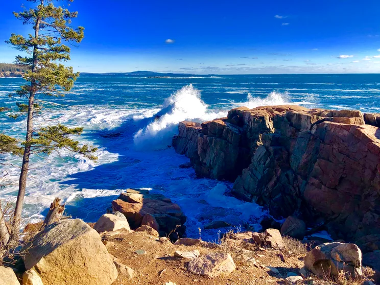 Surf breaking hard against the pink granite ledges of the Acadia shoreline