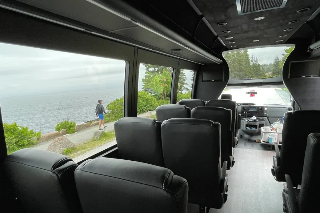 The Atlantic coast along Ocean Drive seen through the large windows of an Acadia tour coach
