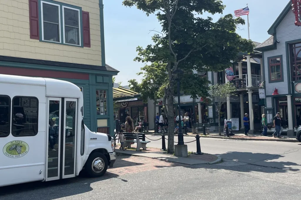 The Acadia National Park Tours shuttle at the Main Street curb outside Testa's restaurant in downtown Bar Harbor