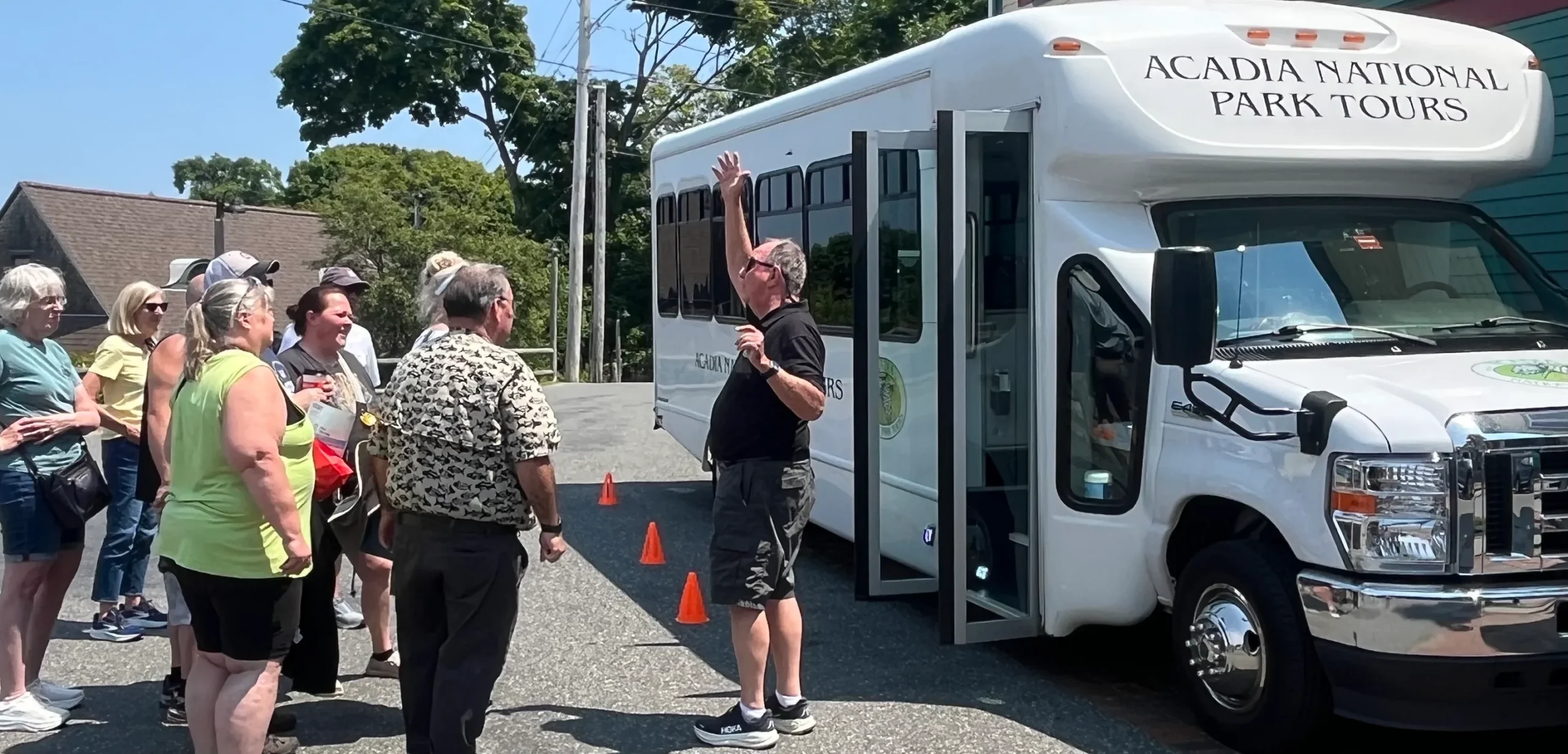 An Acadia National Park Tours guide giving the pre-tour orientation to guests beside the bus