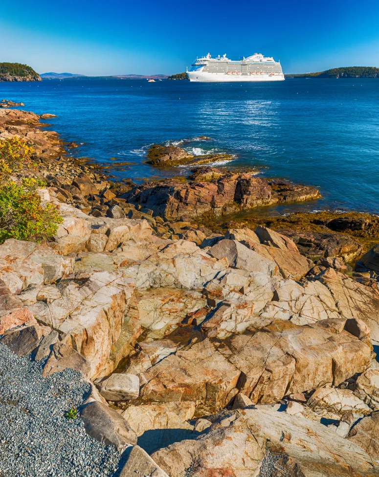 A cruise ship anchored off the rocky Bar Harbor shoreline in Acadia