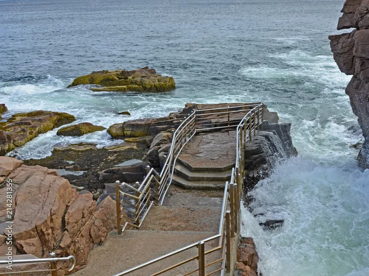 Surf surging through the granite chasm at Thunder Hole below the railed viewing stairway